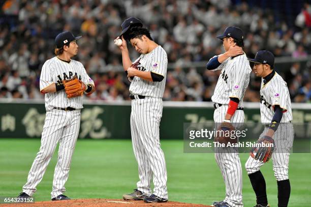Infielders gather to the mound to talk to Pitcher Tomoyuki Sugano of Japan in the top of fourth inning during the World Baseball Classic Pool E Game...