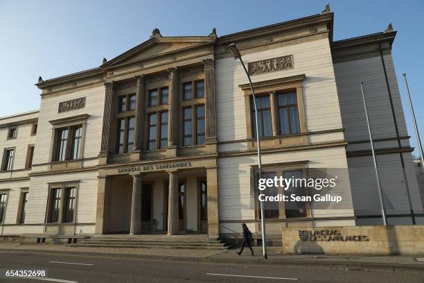 Young woman walks past the Saarland state parliament building on March 16, 2017 in Saarbruecken, Germany. Saarbruecken is in the industrial heartland...