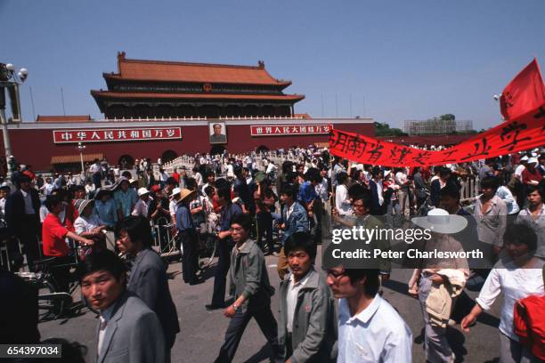 Massive march of flag-waving pro-democracy demonstrators files past the portrait of Mao Tse Tung at the entrance to the Forbidden City in Tiananmen...