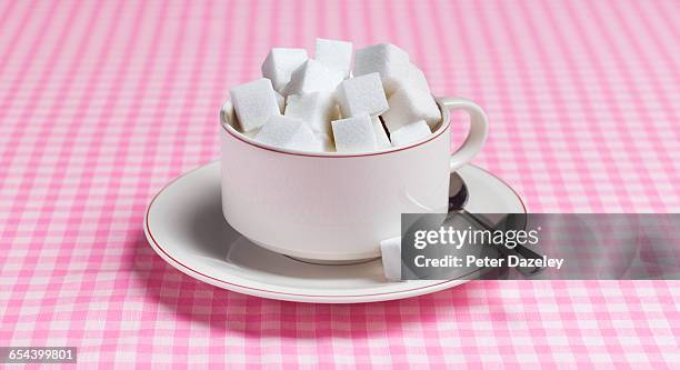 teacup full of sugar lumps - sugar cube stock pictures, royalty-free photos & images