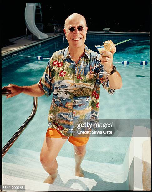 man with cocktail by pool - hawaiian shirt imagens e fotografias de stock