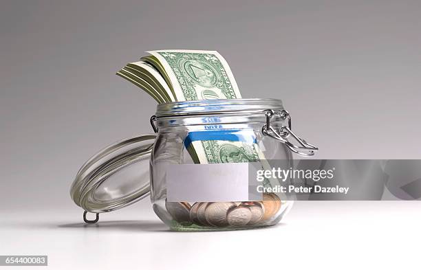 dollars in jar with copy space - saving for a rainy day englische redewendung stock-fotos und bilder