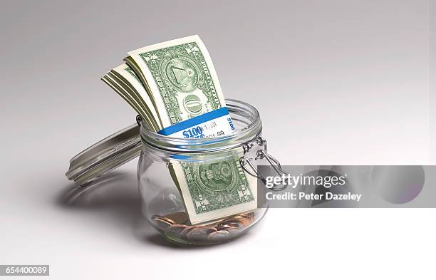 close up of dollars in jar - saving for a rainy day englische redewendung stock-fotos und bilder