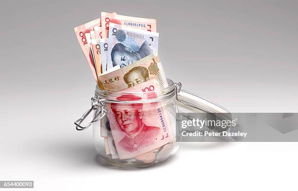 chinese yuan savings in jar - saving for a rainy day englische redewendung stock-fotos und bilder