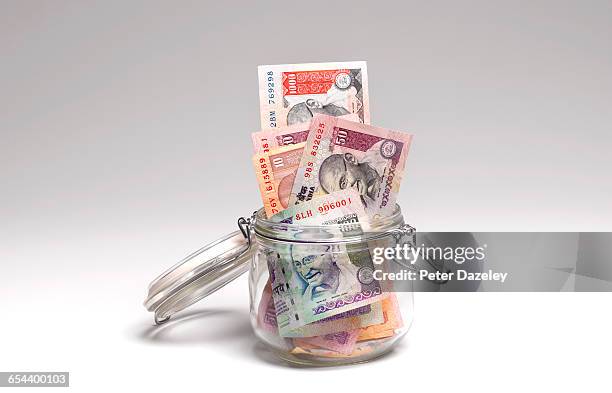 rupees savings in jar - indian currency stock-fotos und bilder