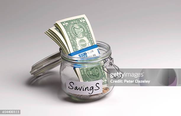 us dollar in savings jar - saving for a rainy day englische redewendung stock-fotos und bilder