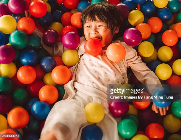 lovely little girl playing joyfully in ball pit - kids playing imagens e fotografias de stock