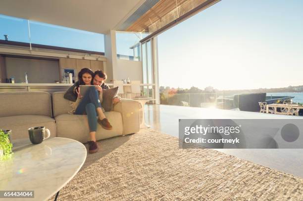 couple at home using a digital tablet. - luxury mansion interior stock pictures, royalty-free photos & images