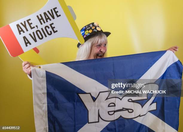 Delegate holds a Saltire flag, with with words "Yes2", referring to a second Independence Referendum, as she poses for a photograph during the...