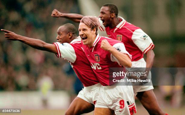 Ian Wright of Arsenal leads the celebrations with a little help from teammates Paul Merson and Patrick Vieira during the FA Carling Premier league...