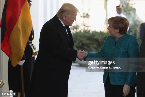 President Donald Trump shakes hands with German Chancellor Angela Merkel as she arrives to the White House on March 17, 2017 in Washington, DC.