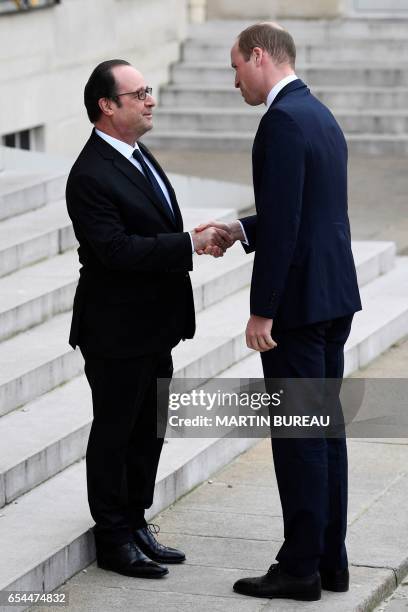 French President Francois Hollande welcomes Britain's Prince William, The Duke of Cambridge at the Elysee Palace in Paris on March 17, 2017. British...