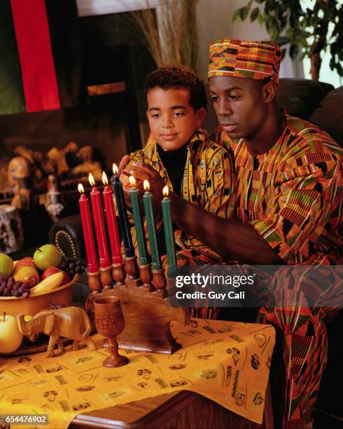 father and son lighting candles - kwanzaa celebration stock pictures, royalty-free photos & images