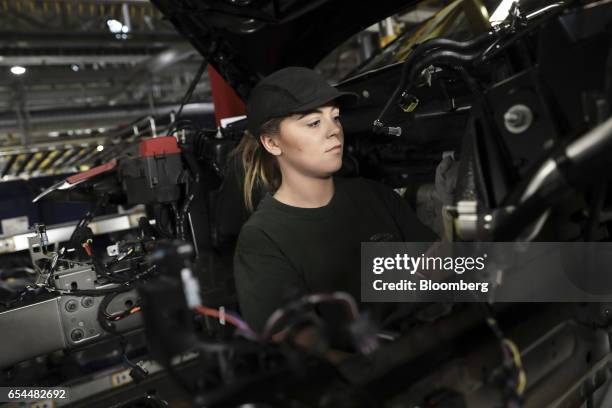 An employee works on a Jaguar XJ automobile in the final inspection area on the production line at Tata Motors Ltd.'s Jaguar assembly plant in Castle...