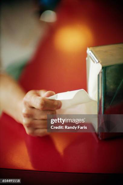 hand pulling napkin out of dispenser - serviettenring stock-fotos und bilder