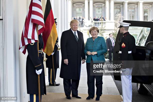 President Donald Trump and Angela Merkel, Germany's chancellor, right, stand for photographs as she arrives to the West Wing of the White House in...