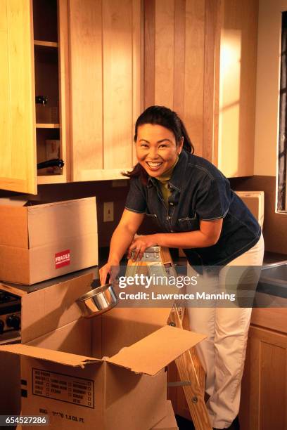 woman unpacking kitchen items - lawrence lader stock pictures, royalty-free photos & images