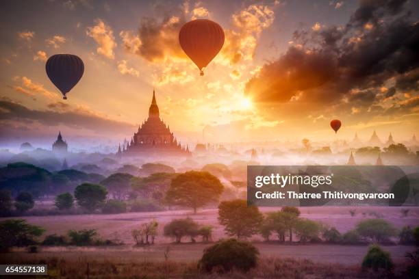 hot air balloon over plain of bagan in misty morning, mandalay, myanmar - bagan stock-fotos und bilder