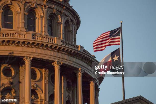 An American flag flies with the Texas state flag outside the Texas State Capitol building in Austin, Texas, U.S., on Tuesday, March 14, 2017. Austin...