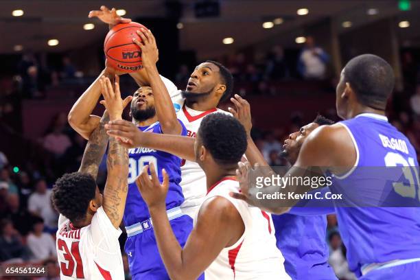 Madison Jones of the Seton Hall Pirates is fouled by Anton Beard of the Arkansas Razorbacks as Arlando Cook goes for the block from behind in the...