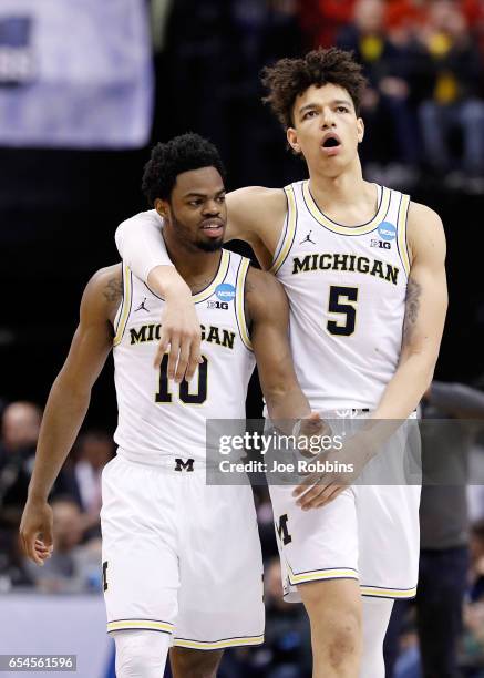 Derrick Walton Jr. #10 of the Michigan Wolverines celebrates with D.J. Wilson against the Oklahoma State Cowboys during the first round of the 2017...