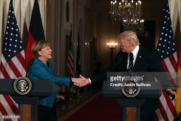President Donald Trump shakes hands with German Chancellor Angela Merkel during a joint press conference in the East Room of the White House on March...