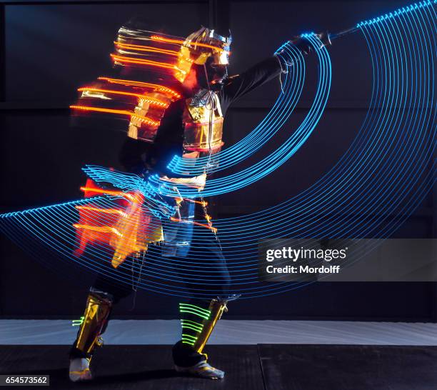 samurai in led kostuum vertoont dans van licht - samoerai stockfoto's en -beelden