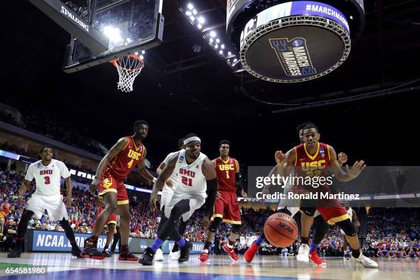 Ben Emelogu II of the Southern Methodist Mustangs and De'Anthony Melton of the USC Trojans compete for a loose ball during the first round of the...