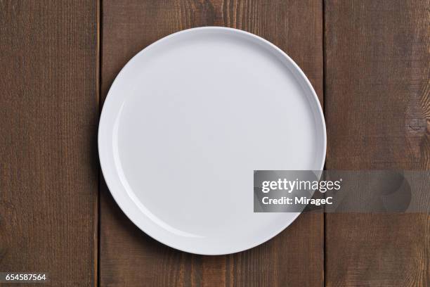 empty white plate on wood table - vlak erboven stockfoto's en -beelden