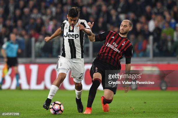 Paulo Dybala of Juventus FC is challenged by Gabriel Paletta of AC Milan during the Serie A match between Juventus FC and AC Milan at Juventus...