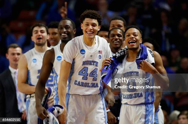 Theo Pinson, Justin Jackson, Nate Britt of the North Carolina Tar Heels and teammate cheer from the bench in the second half against the Texas...