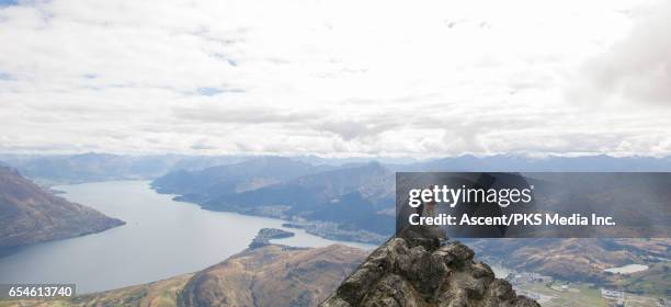 hiking couple stand on mountain summit, looking out - queenstown new zealand stock pictures, royalty-free photos & images