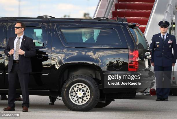 President Donald Trump waves to people as his son, Barron Trump sits in the vehicle with him after arriving on Air Force One at the Palm Beach...