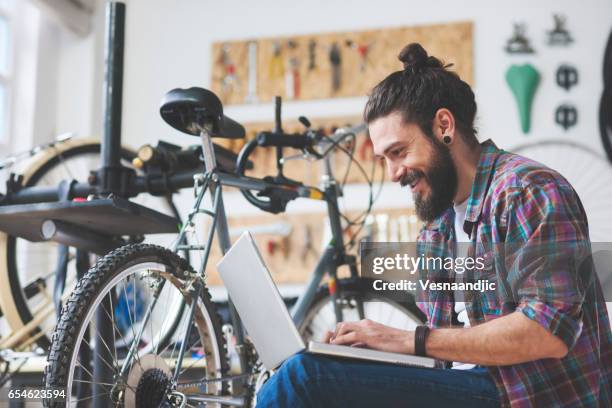 de reparatie fiets reparateur in werkplaats - fietsenwinkel stockfoto's en -beelden