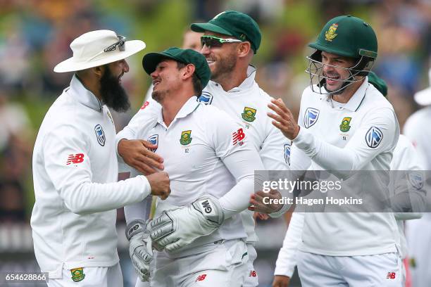 Quentin de Kock of South Africa is congratulated by teammates Faf du Plessis, Hashim Amla and Stephen Cook after taking a catch to dismiss Neil Broom...