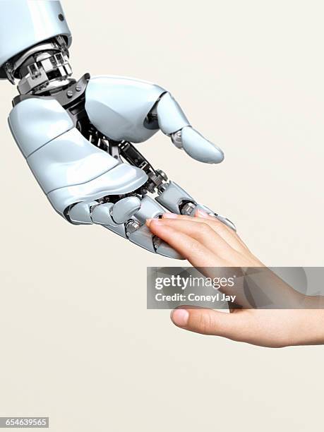 robot hand touching child's fingertips - roboterarm stock-fotos und bilder