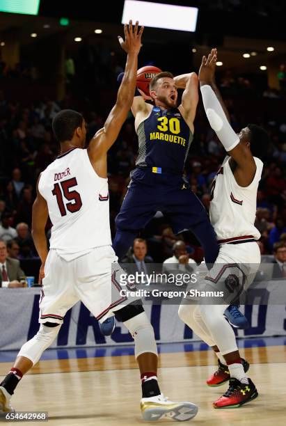 Andrew Rowsey of the Marquette Golden Eagles passes against PJ Dozier and Duane Notice of the South Carolina Gamecocks in the first half during the...