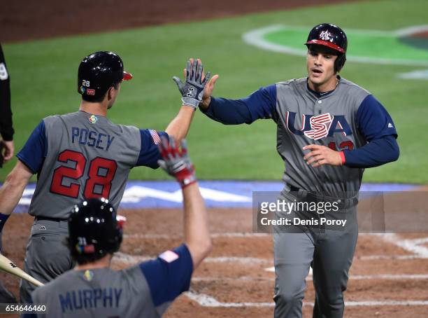 Nolan Arenado of the United States, right, is congratulated by Buster Posey of the United States after scoring during the second inning of the World...