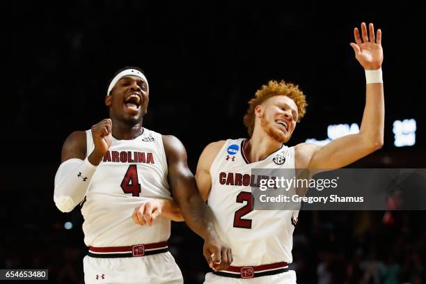 Rakym Felder and Hassani Gravett of the South Carolina Gamecocks celebrate their 93-73 win over the Marquette Golden Eagles during the first round of...