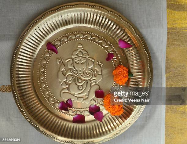 lord ganesha engraved on a copper plate/flowers - ganesh chaturthi fotografías e imágenes de stock