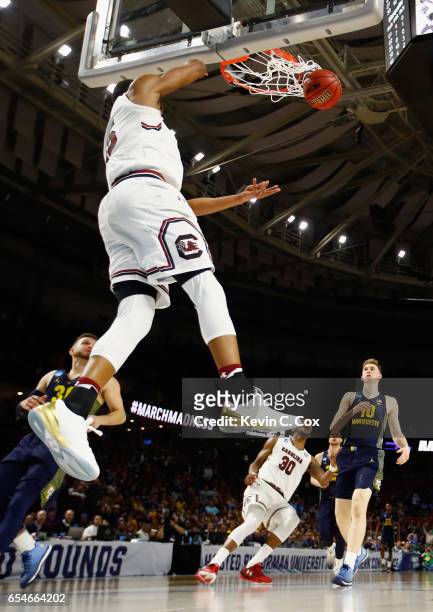 Dozier of the South Carolina Gamecocks dunks against Andrew Rowsey of the Marquette Golden Eagles in the second half during the first round of the...