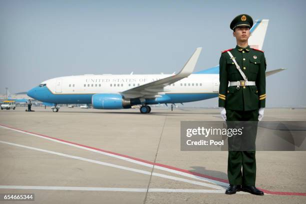 Chinese paramilitary policeman stands guard as a plane carrying U.S. Secretary of State Rex Tillerson arrives at Beijing Capital International...