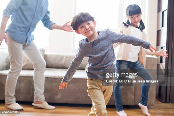 happy young family dancing together - girls modern room stock-fotos und bilder