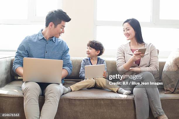 happy young family using laptop and digital tablet - autonomo smartphone tablet stock-fotos und bilder