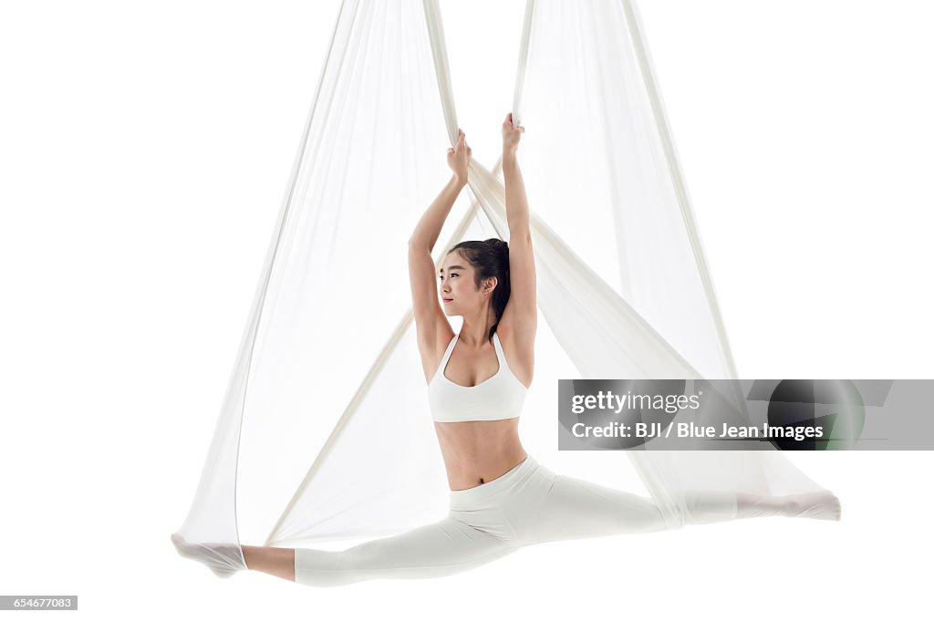Young woman practicing aerial yoga