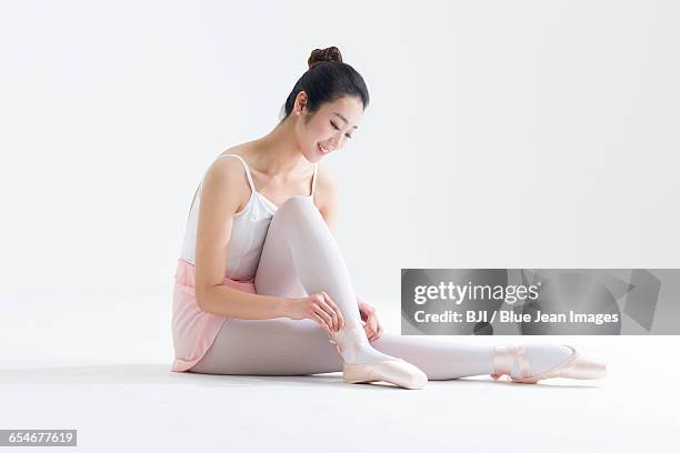 ballet dancer tying up pointe shoes - lace fastener stock-fotos und bilder