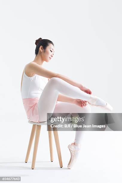 ballet dancer tying up pointe shoes - lace fastener stock-fotos und bilder