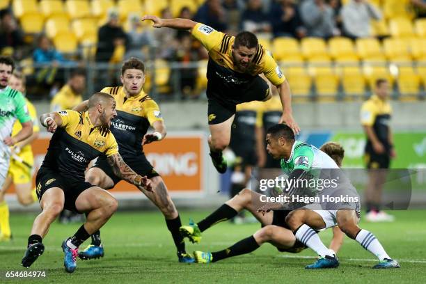 Aaron Smith of the Highlanders attepmts to break the defense of TJ Perenara, Beauden Barrett, Dane Coles and Jordie Barrett of the Hurricanes during...