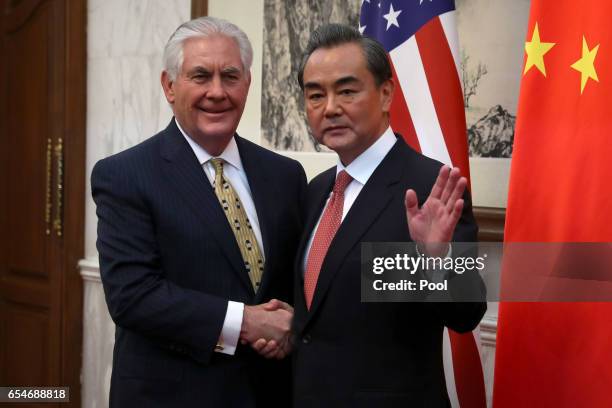 Secretary of State Rex Tillerson, left, shakes hands with with Chinese Foreign Minister Wang Yi, right, as he arrives for a bilateral meeting with...