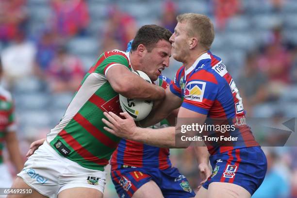 Sam Burgess of the Rabbitohs is tackled by Mitchell Barnett of the Knights during the round three NRL match between the Newcastle Knights and the...